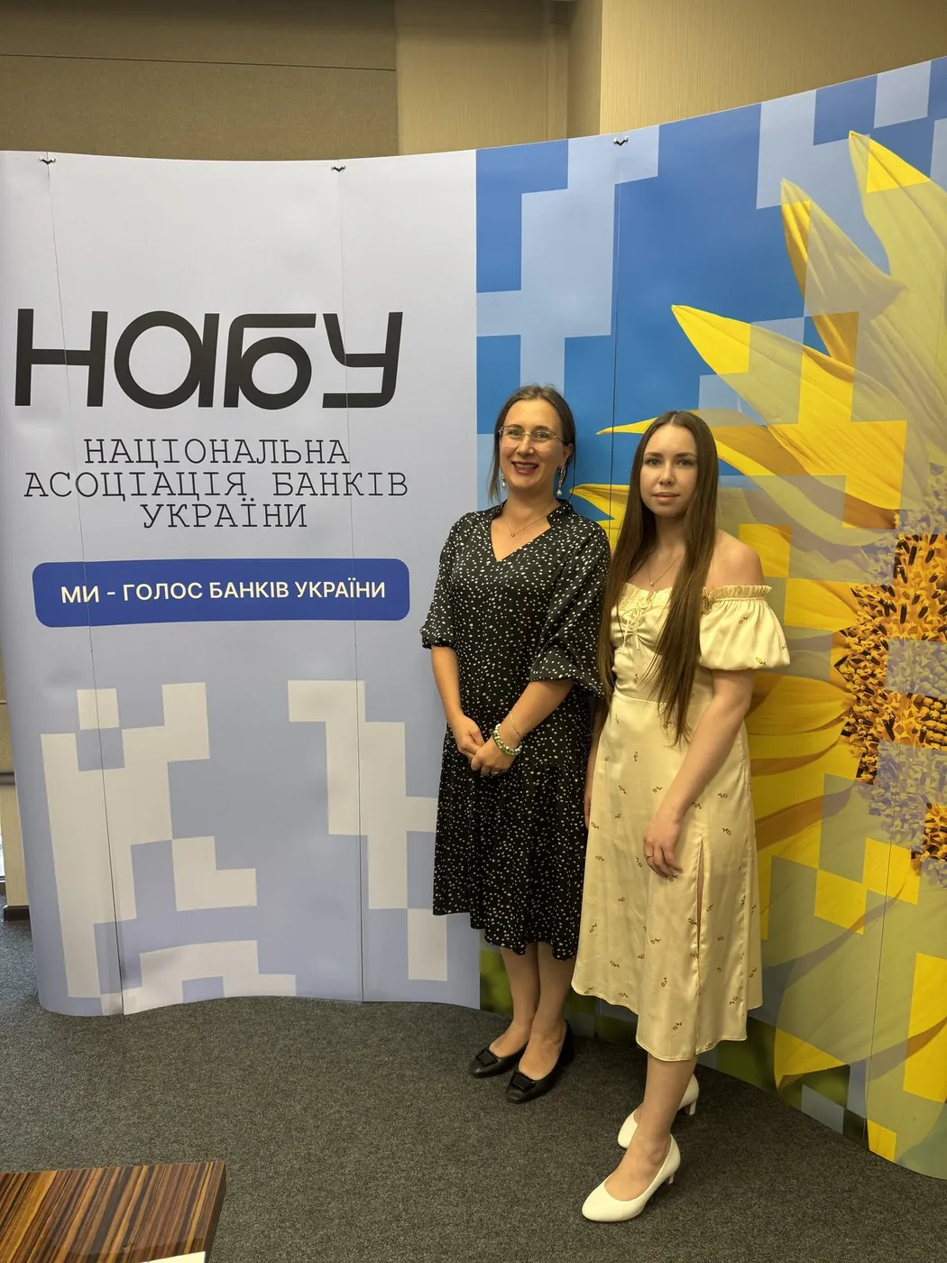 Дві представниці фонду біля банера Національної асоціації банків України