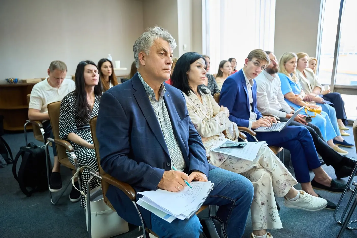 Слухачі в першому ряду, один із них записує