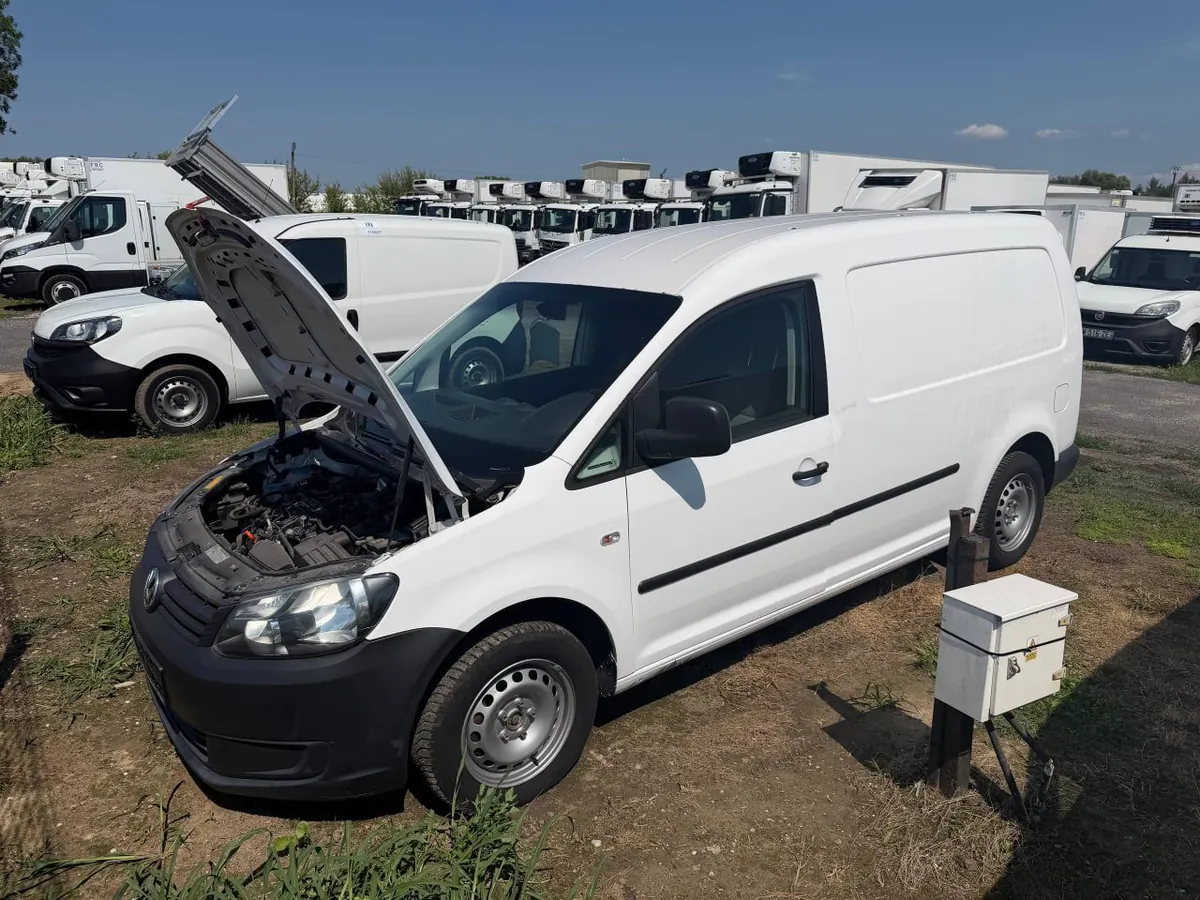 Білий фургон Volkswagen Caddy з піднятим капотом на майданчику продавця, позаду ряд рефрижераторів