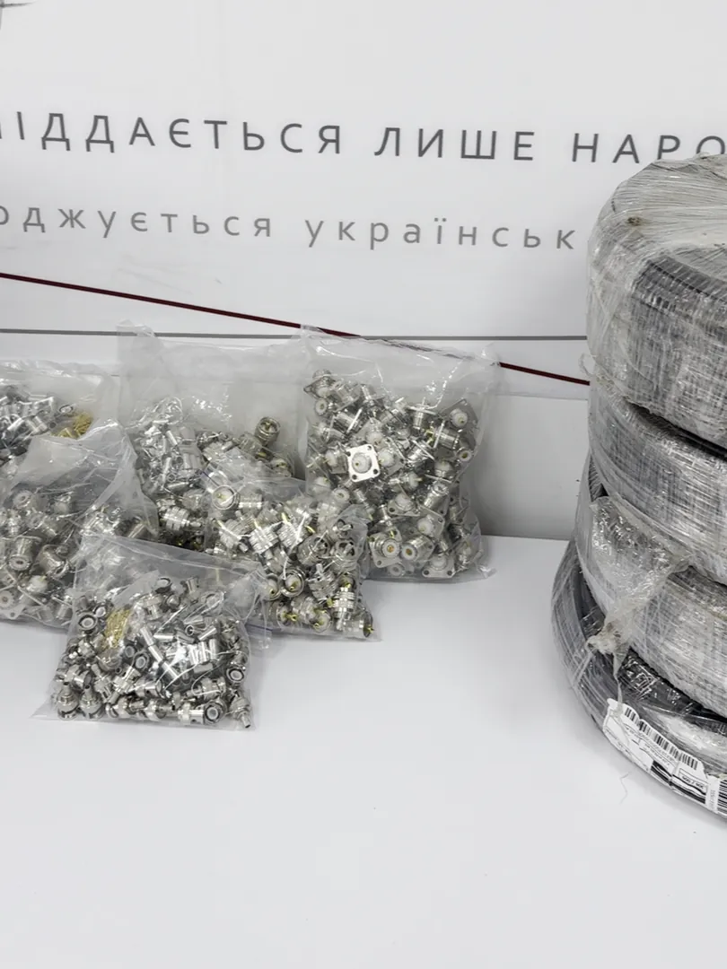 Прозорі пакети з металевими роз’ємами й гніздами поруч із бухтою кабелю в плівці